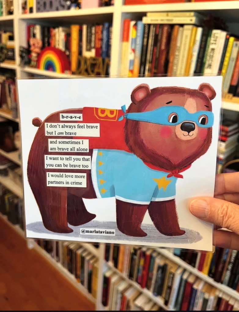 Hand-collaged word art on an illustrated storybook page of a brown bear in a blue superhero mask and cape. Marla Taviano's poem "b-r-a-v-e" glued onto the artwork.