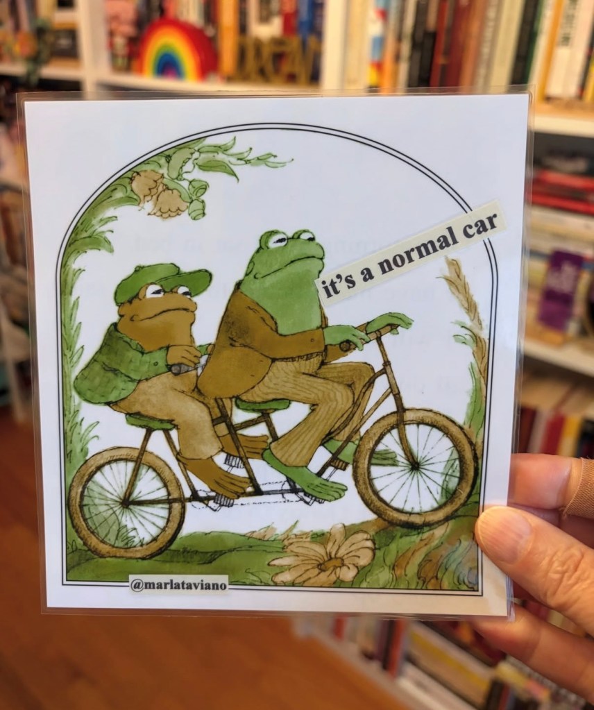 Hand-collaged word art on an illustrated page of a frog and toad riding a tandem bicycle through a garden archway. The line "it's a normal car" glued onto the artwork.